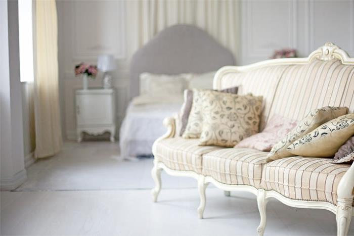 elegant lantlig inredning, taupe sänggavel, vitt sängbord, rosebukett, blommiga kuddar