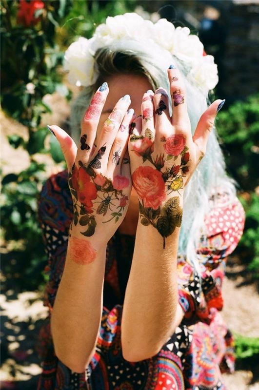 Tatuaggi sulle dita di una ragazza con fiori e farfalle colorate