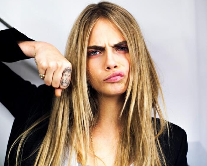 Tatuaggi sulle dita di Cara Delevingne con il disegno di un leone sull'indice