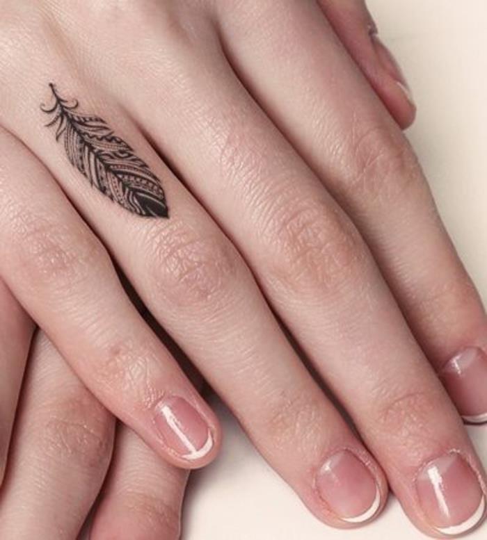 وشم sulle mani e un'idea per tatuaggio piuma sul dito anulare di una donna