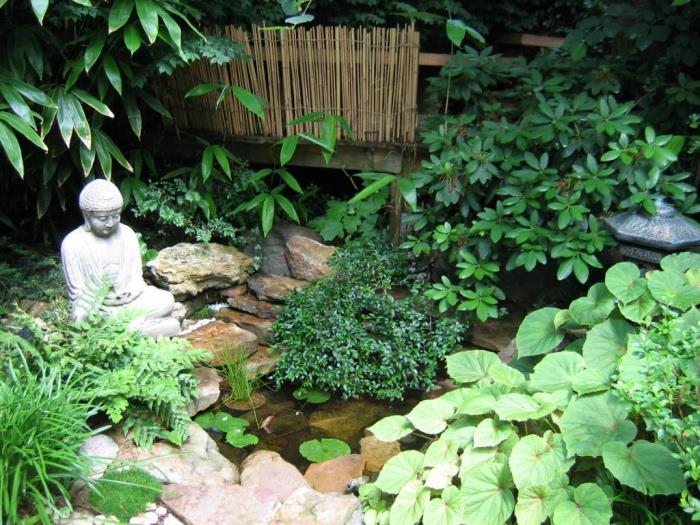 زخرفة حديقة زن ، بركة ماء صغيرة ، نافورة ، محاطة بالحجارة ، تمثال بوذا ، نباتات خضراء