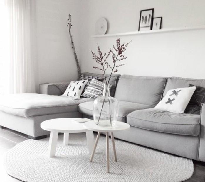 Mobili soggiorno moderni, divano di colore grigio, due tavolini rotondi