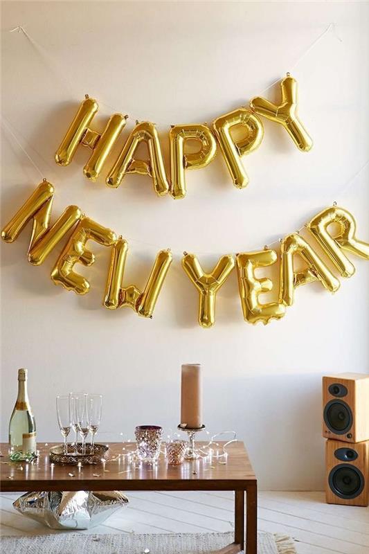 ballong i bokstäver gott nytt år i guld, soffbord i trä och ljus kransdekoration, silverstjärnig ballong i silver