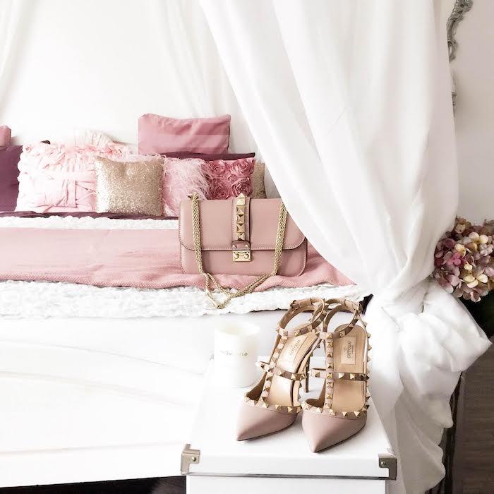 feminina accessoarer i pastellrosa, vita och rosa dekorationer av ett kvinnors rum, blekrosa fuskpälskuddar