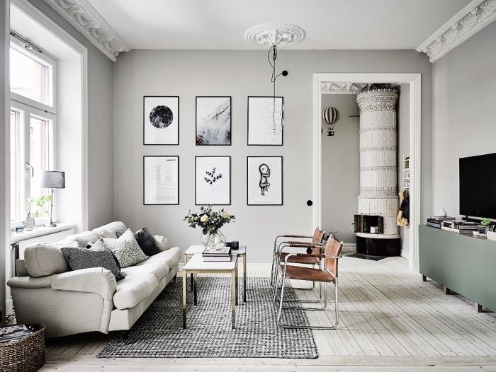 škandinávske usporiadanie obývačky, sivá farba steny a pohovky, hnedé stoličky, sivý koberec, konferenčné stolíky, pastelovo zelená televízna skrinka, grafická dekorácia steny