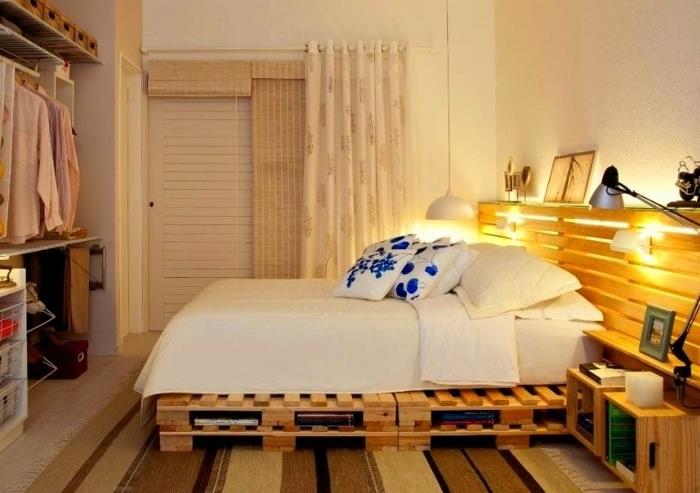 فكرة كيفية صنع سرير بمنصة نقالة مع لوح أمامي ومنصة بيضاء وبياضات سرير بيضاء ووسائد بيضاء بنقوش زهور زرقاء وديكو بسيط للاسترداد