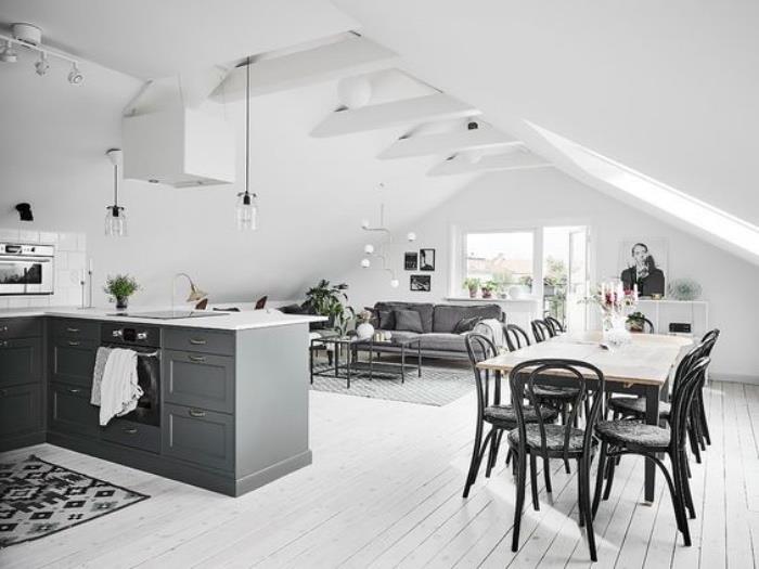 utrustat kök med grå köksö, vitkalkat parkettgolv, grå matta och soffa, soffbord, plats för vardagsrum / matsal med träbord och svarta stolar