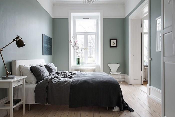 spálňa s celadonovými modrými stenami, scamdimabe deco, svetlé parkety, biela posteľ so sivou posteľnou bielizňou, biely nočný stolík