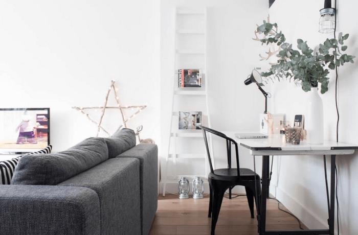 nápad na bielu škandinávsku obývačku, sivá sedačka, svetlé parkety, biely stôl s čiernou kovovou stoličkou, úložisko na časopisy s bielym rebríkom