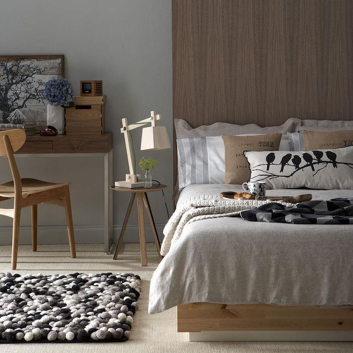 hnedý a sivý dekor spálne pre dospelých, sivý a čierny koberec, drevený stôl a stoličky, posteľ so sivým, bielym a béžovým ľanom, dekorácia spálne