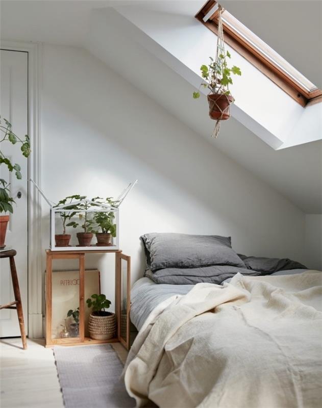 dekorácia spálne pod svahom, biela a sivá posteľná bielizeň, sivý koberec, svetlé parkety, dekorácia zelených rastlín, škandinávska inšpirácia
