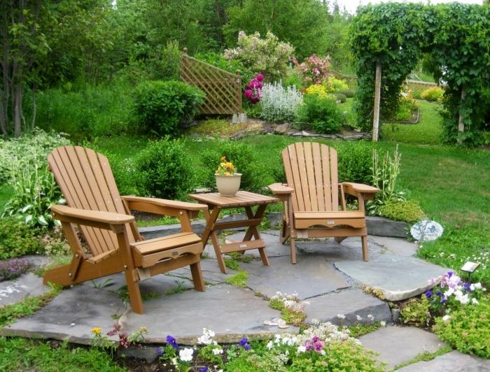 حديقة زين ، العشب والزهور ، أرضية حجرية ، منطقة استراحة ، طاولة خشبية وكرسي للاستلقاء ، نباتات مزدهرة
