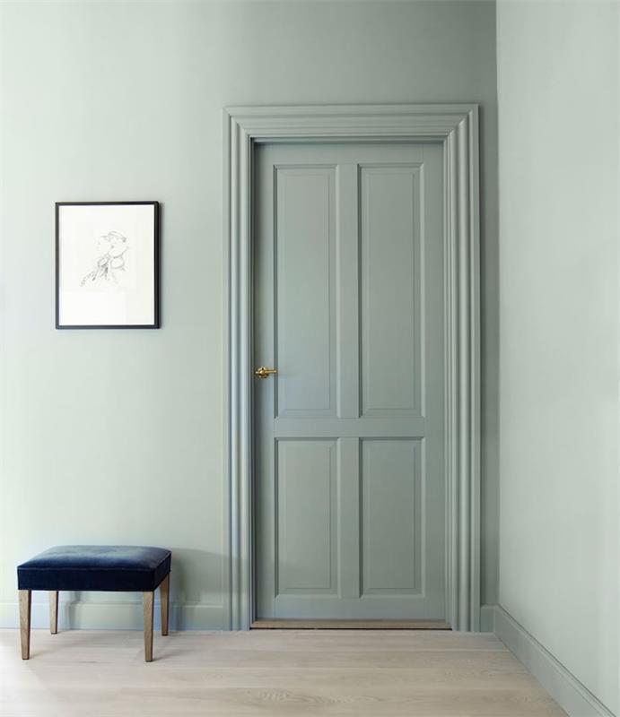 elegantný dizajn, farba na stenu a dvere namaľované celadon verdigris, svetlé parkety, tmavo modrá stolička, grafická dekorácia steny