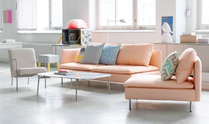 pastelový škandinávsky nábytok, lososová sedačka, sivé kreslo, biela podlaha a biele steny, konferenčný stolík, priestranná obývačka