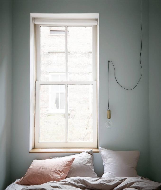 Nápad na výzdobu spálne pre dospelých, malý priestor, svetlošedá stena, sivá posteľná bielizeň, ružové, svetlo sivé a lososové vankúše, závesné svetlo žiarovky