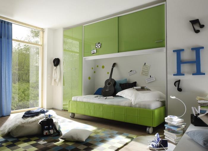ديكور غرفة نوم صبي صغير ، سقف أبيض مع أثاث أخضر ، ستائر زرقاء طويلة ، ديكور نوتة موسيقية باللون الأسود