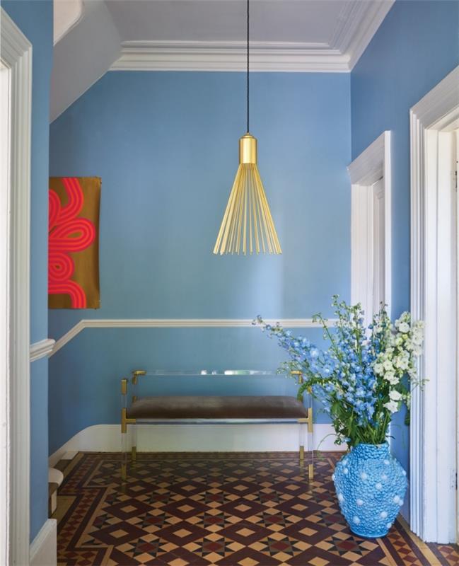Deco -idékorridor med väggar målade i ljus ljusblå färg markerade med några gyllene accenter och keramiska plattor i jordfärger