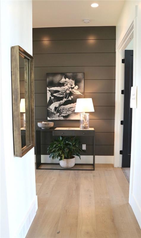 liten vit hall i en modern lägenhet med bakväggen klädd i träplankor målade mörkbruna