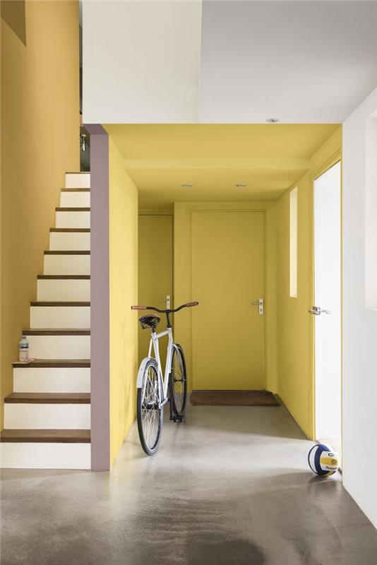 lysande entré och trapphus målat i en ockra nyans av gul skapar en känsla av värme, korridors färgdyner i sahara av dulux valentine