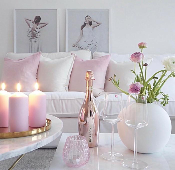 romantisk och feminin atmosfär i vardagsrummet i vitt och rosa, flaska champagne på marmorbord