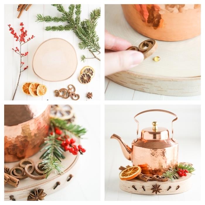 Dekorácia na vianočný stôl vlastnoručne vyrobená, medená čajová kanvica na drevenom poli ozdobená škoricovými tyčinkami, plátkami pomaranča, vetvičkami cezmíny a borovice