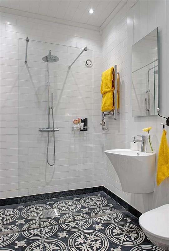 zdobená dlažba v kúpeľni a otvorený sprchovací kút so sklenenou centrálnou stenou