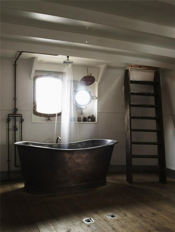 jednoduchá kúpeľňa, veľká liatinová vaňa, drevený rebrík, biely strop, drevená podlaha, odhalený sprchovací kút, zrkadlo a osvetlenie s priemyselnou lampou