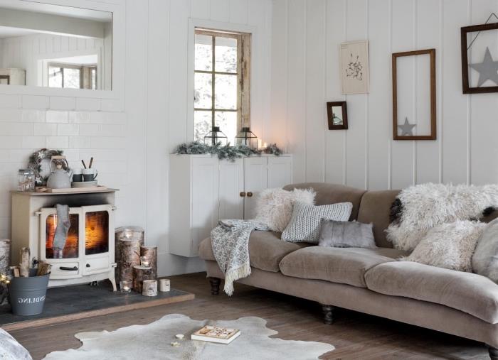 traditionell skandinavisk vardagsrumsinredning i nordisk festlig anda med en mjuk soffa täckt med mysiga kuddar och en fuskpälspläd, rustikt, elegant eldstadshörna