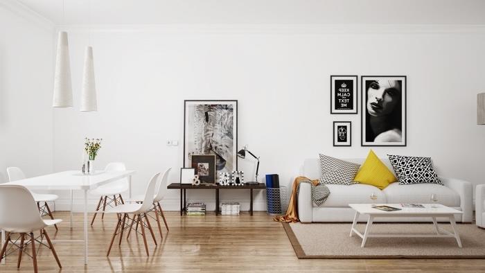 výzdoba obývačky a jedálne v škandinávskom dome, svetlé parkety, biela sedačka, žltý, čiernobiely vankúš, biely konferenčný stolík, jedálenský kút, biely stôl a stoličky, grafická výzdoba