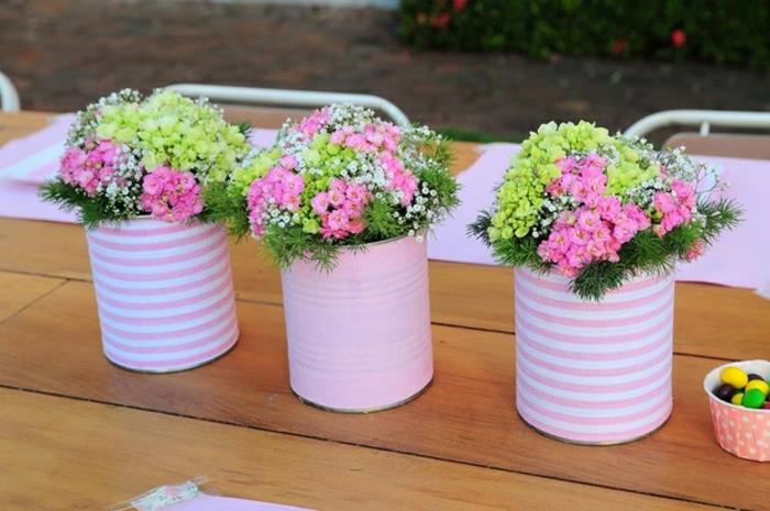 små anpassade blomkrukor i rosa papper och randigt papper, buketter av lantliga blommor, rustikt träbord, idé för bröllopsinredning, återvinning av burk
