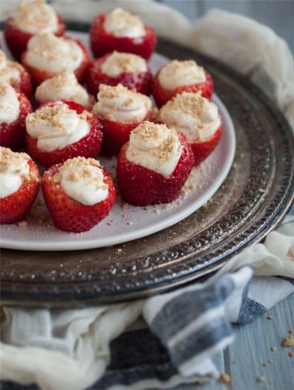 lätt fruktdessert, jordgubbar fyllda med färskost med ströade krossade kakor