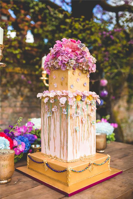 förbereda en original bröllopstårta i geometriska former och blomsterdekoration, guldbas, original blomkakaidé