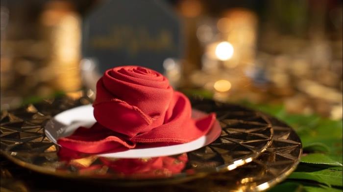 skladací model obrúskov pre štýlové Vianoce, vyrobte si červenú látkovú ružu na slávnostnú výzdobu stola, nápad s kvetinovým obrúskom