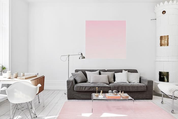 grått och vitt vardagsrum med dekorativa föremål i pastellrosa, ljust träbord med vit stol