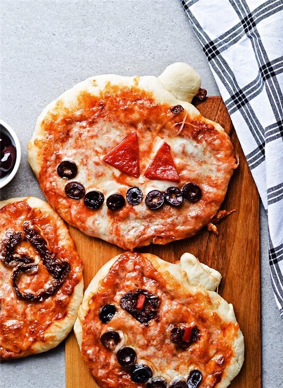 strašidelná halloweenska pizza z tekvice, mini halloweenska pizza so syrom, paradajkami a olivami