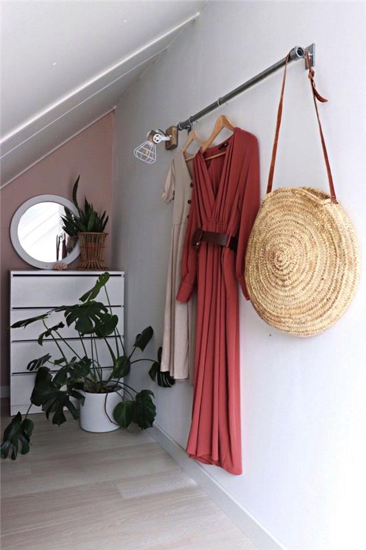 idé om omklädningsrum på vinden, hörnomklädningsrum under sluttningen med hängskena fixerad på väggen och liten byrå
