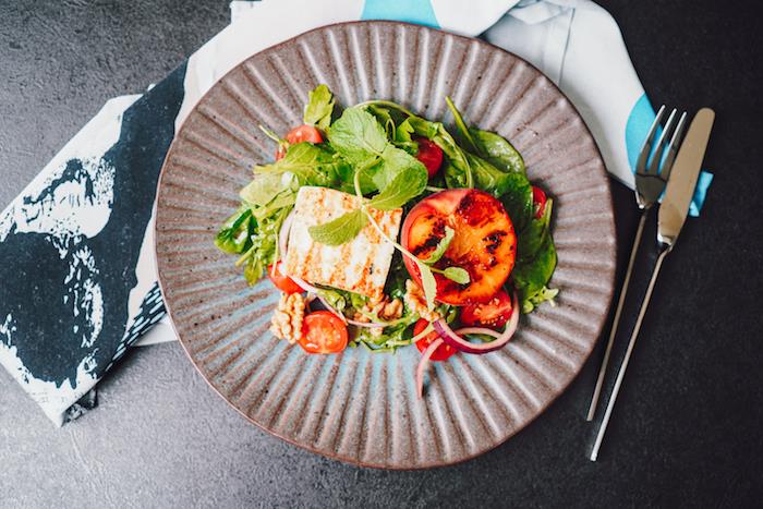 nápad na výrobu zeleného šalátu zo špenátovej rukoly halloumi a grilovaných vlašských orechov a cherry paradajok