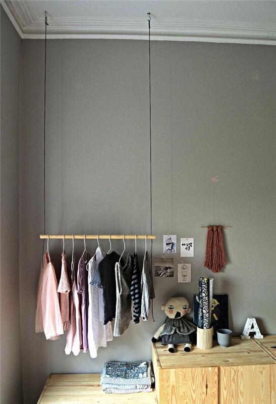 omklädningshörna barns sovrum med hängande skåp på väggen ovanför träskåpet