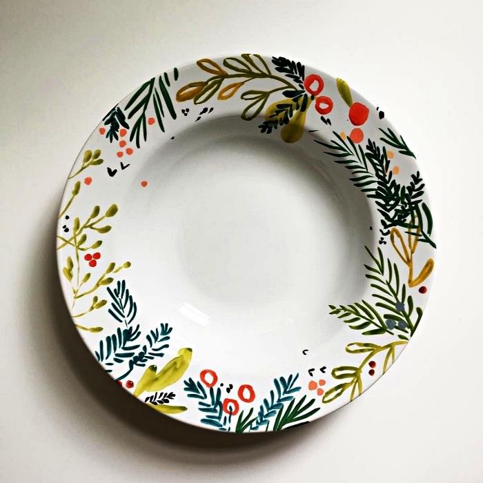 prispôsobte biely tanier keramickou farbou, namaľujte vzory rastlín na tanier pre vianočný dizajn