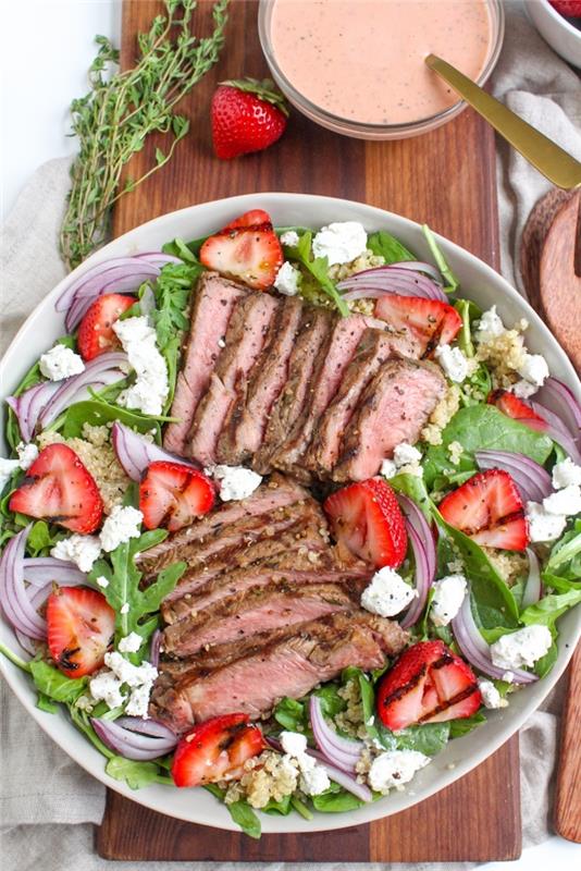 nápad na večeru miešaný šalát s rukolou, špenát, jahody, strúhanka zo syra feta a bravčový steak s quinoa