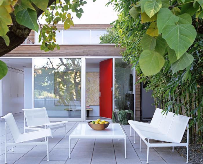idé om trädgårdsmöbler på en välkomnande terrass, som täcker betongplattor, soffbord, vit soffa och stolar, bambu och andra växter