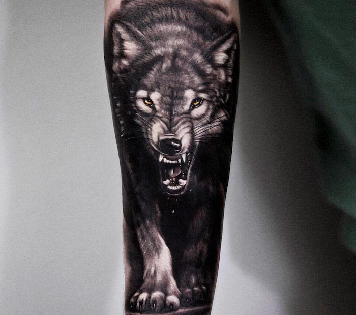 symbol tetovania, kresba na koži pre muža, obraz vlka so žltými očami a divokou tvárou na ruke