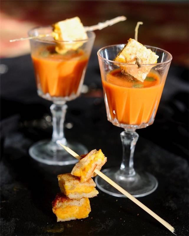 predstava aperitívu pohár paradajkovej polievky so syrom medzi plátkami chleba