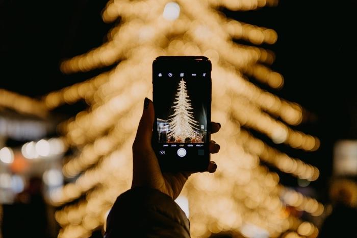 nápad, ako fotografovať v noci, fotografie vianočného stromčeka ozdobeného zlatými svetelnými girlandami