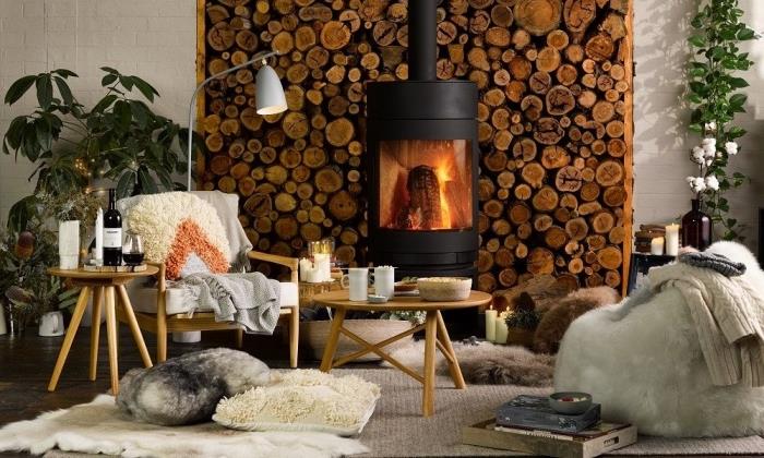 mysigt öppen spis hörn med mjuka material och naturliga dekorativa detaljer, skandinavisk stil hygge deco hörn med kuddar kastade på golvet, en mysig ottoman