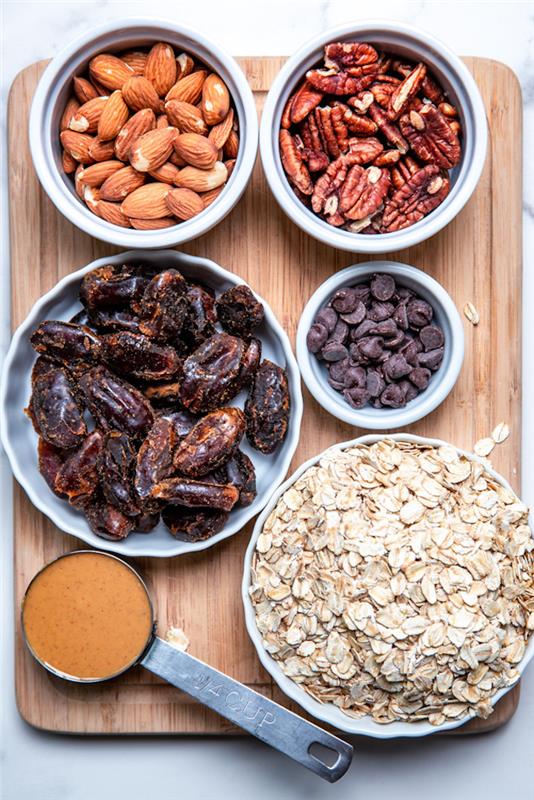 suroviny potrebné na výrobu domácich proteínových tyčiniek, datlí, mandlí a pekanových orechov, čokoládových lupienkov, ovsených vločiek
