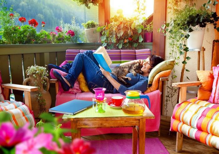 ألوان جميلة وإطلالة من الشرفة ، امرأة مع قطتها تقرأ كتابًا ، وتنسيق الحدائق الصغيرة ، وأفكار للشرفات الخارجية والديكور الجميل