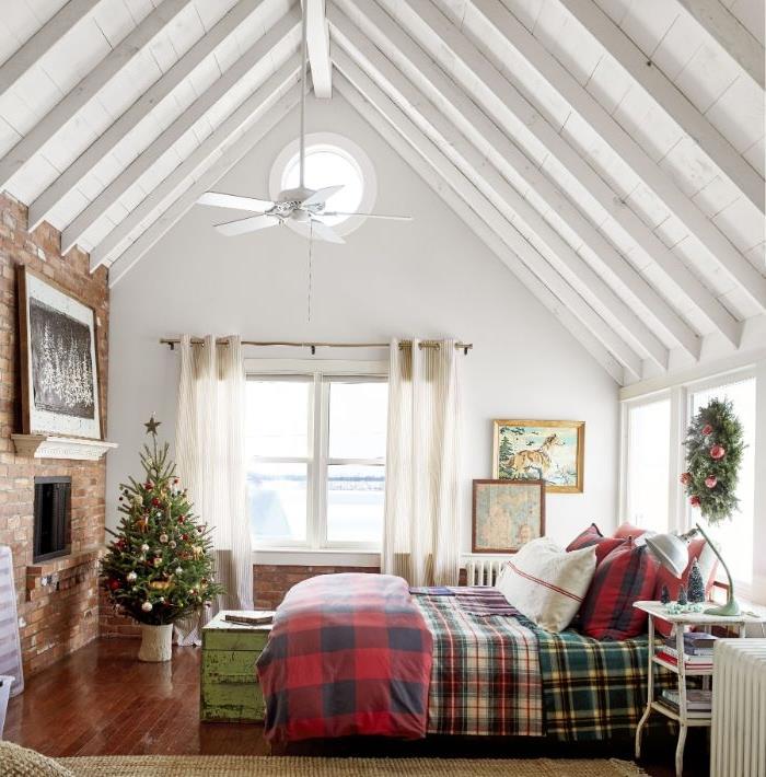 interiér chata deco dekorácia kokonovanie spálňa skontrolovaná posteľná bielizeň parkety prelakované vianočný stromček ozdobený koniec postele truhlica krb tehla biele odhalené trámy