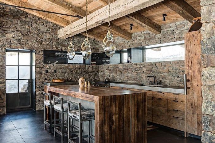 zrekonštruovaná kuchyňa na statku s odhalenou kamennou stenou vo vnútri a pôvodným dreveným rámom