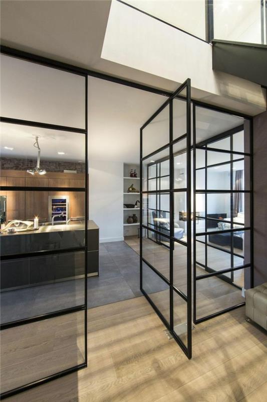 posuvná interiérová sklenená strecha, čierne sklenené dvere s bočným otváraním, priemyselná kuchyňa z betónu a dreva